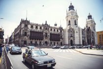 Carrefour de la circulation sur la place principale et façade de la cathédrale à Lima, Pérou . — Photo de stock