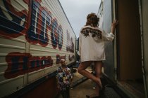 Girl in shirt standing on stairs of trailer — Stock Photo