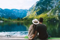 Пара сидящих у горного озера — стоковое фото