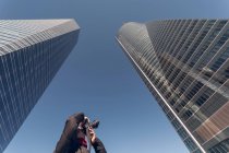 Uomo scattare foto di grattacieli nel centro finanziario — Foto stock
