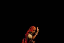 INDIA - 12 de octubre de 2011: Persona vestida con ropa tradicional y bailando sobre fondo negro , - foto de stock