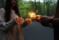 Couple with sparklers in woods — Stock Photo