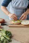 Cocinar preparando sándwich con aguacate - foto de stock