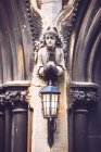Angel statue holding lanterns at arch of church — Stock Photo