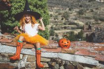 Menina em traje de Halloween posando no telhado — Fotografia de Stock