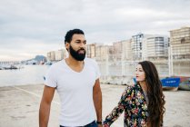 Paar hält Händchen und geht auf Küstenstraße — Stockfoto