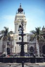 Stadtbrunnen auf dem Hintergrund eines verzierten Turms am Hauptplatz von Lima, Peru. — Stockfoto