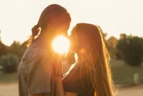 Porträt eines Paares, das sich bei Sonnenuntergang umarmt und von Angesicht zu Angesicht sieht — Stockfoto