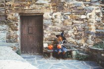 Fille en costume de sorcière assis sur le banc — Photo de stock