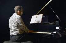 Uomo anziano che suona il pianoforte sul palco — Foto stock