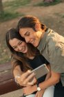 High angle portrait of young smiling couple taking selfie with smartphone. — Stock Photo
