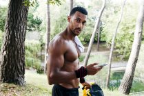 Bodybuilder uomo utilizzando smartphone — Foto stock