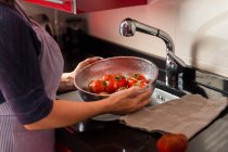 Cocinar lavando tomates frescos - foto de stock