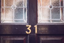 Number on wooden door — Stock Photo