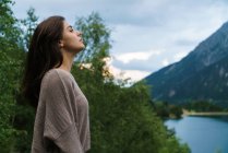 Brünette Mädchen posiert über Bergsee — Stockfoto