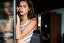 Pretty woman leaning at closet and looking at camera — Stock Photo