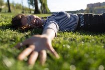 Visão de nível de superfície da mulher deitada na grama — Fotografia de Stock