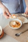 Hands dipping pita bread in hummus — Stock Photo
