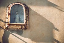 Статуя Девы Марии в стеклянной коробке на фасаде — стоковое фото