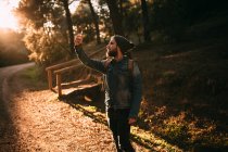 Hombre tomando selfie en camino de otoño soleado - foto de stock