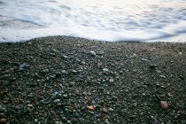 Vista de ángulo alto de la playa de guijarros con espuma de mar — Stock Photo