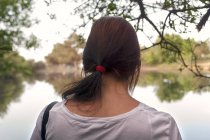 Rear view of brunette girl at lake — Stock Photo