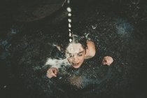 Milk drops pouring on girl in well — Stock Photo