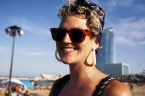 BARCELONA, SPAIN - 10 July, 2011: Portrait of stylish woman in sunglasses posing on background of beach. — Stock Photo