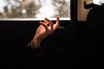 Крупним планом жіноча рука в світлій плямі проти вікна — стокове фото