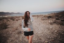 Ritratto di giovane bruna che ride camminando al mare — Foto stock