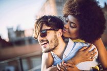 Retrato de pareja interracial abrazándose en la azotea - foto de stock