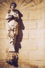 Reich verzierte Flachrelief weibliche Skulptur steht auf Löwenkopf Brunnen auf Fassade — Stockfoto