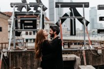 Seitenansicht eines glücklichen Paares, das sich auf dem Dach umarmt — Stockfoto
