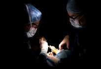 Портрет двух хирургов, проводящих операцию на лодыжке в клинике — стоковое фото