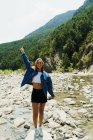 Счастливая девушка позирует на камнях реки — стоковое фото