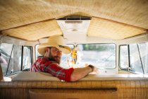 Mann mit Cowboyhut sitzt am Fahrersitz des Transporters und blickt über die Schulter in die Kamera — Stockfoto