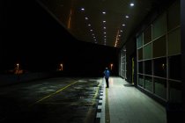Malaysia - 26. April 2016: Seitenansicht eines Mannes, der in der Nacht auf dem Bürgersteig eines Gebäudes mit Parkplätzen steht. — Stockfoto