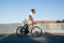 Чорний чоловік їде на велосипеді — стокове фото