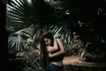 Bruna ragazza posa sopra le foglie di palma — Foto stock