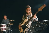 Musicisti che suonano la chitarra e la batteria sul palco — Foto stock