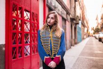Jovem menina séria vestindo casaco uniforme e olhando para a rua — Fotografia de Stock