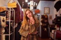 Young girl in posing in fur coat at clothing room and looking at camera — Stock Photo