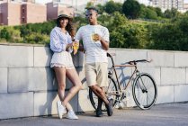 Casal com bebidas e bicicleta — Fotografia de Stock