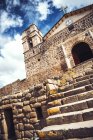 Antique church placed on ancient Inca temple ruins over clouds — Stock Photo