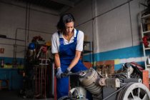 Female mechanic fixing compressor enginge with wrench — Stock Photo