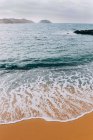Вид на хвилі на піщаний пляж на спокійній береговій лінії — стокове фото