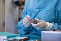 Seção média do médico no ajuste uniforme broca cirúrgica na sala de operação — Fotografia de Stock