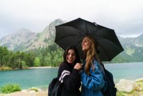 Mujeres bajo paraguas en las montañas - foto de stock