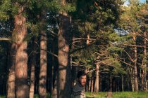 Молодий чоловік в лісі насолоджується сонячним днем — стокове фото