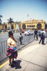 Lima, Peru - 26. Dezember 2016: Frau steht auf der Straße vor dem Hintergrund des Rathauses — Stockfoto